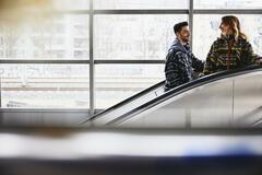 Smiling people on a escalator in a train station.