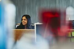 Woman at her desk. India. Primary color: red.