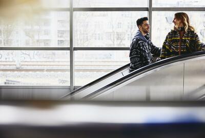 Smiling people on a escalator in a train station.