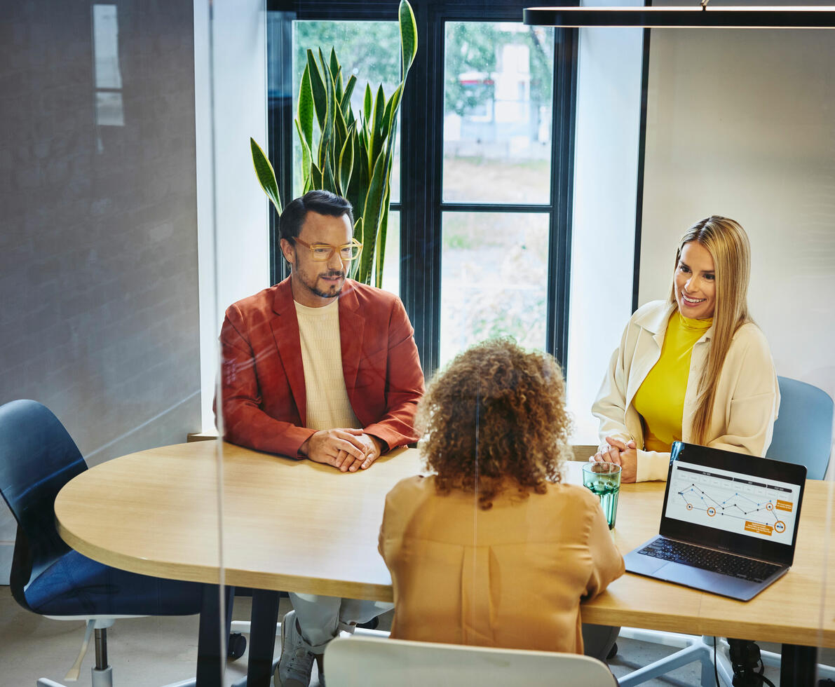 Three colleagues discussing work in the office