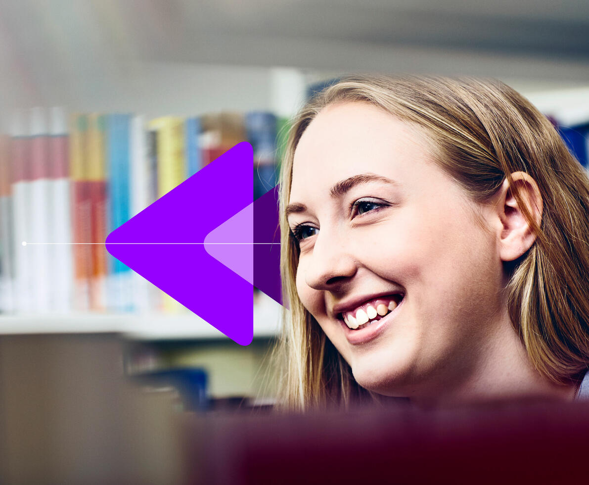 a young woman smiling in a library and looking to the left