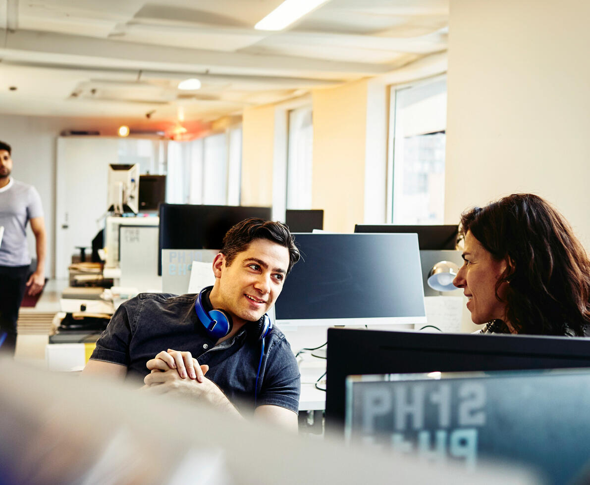 people in conversation in an office boardroom