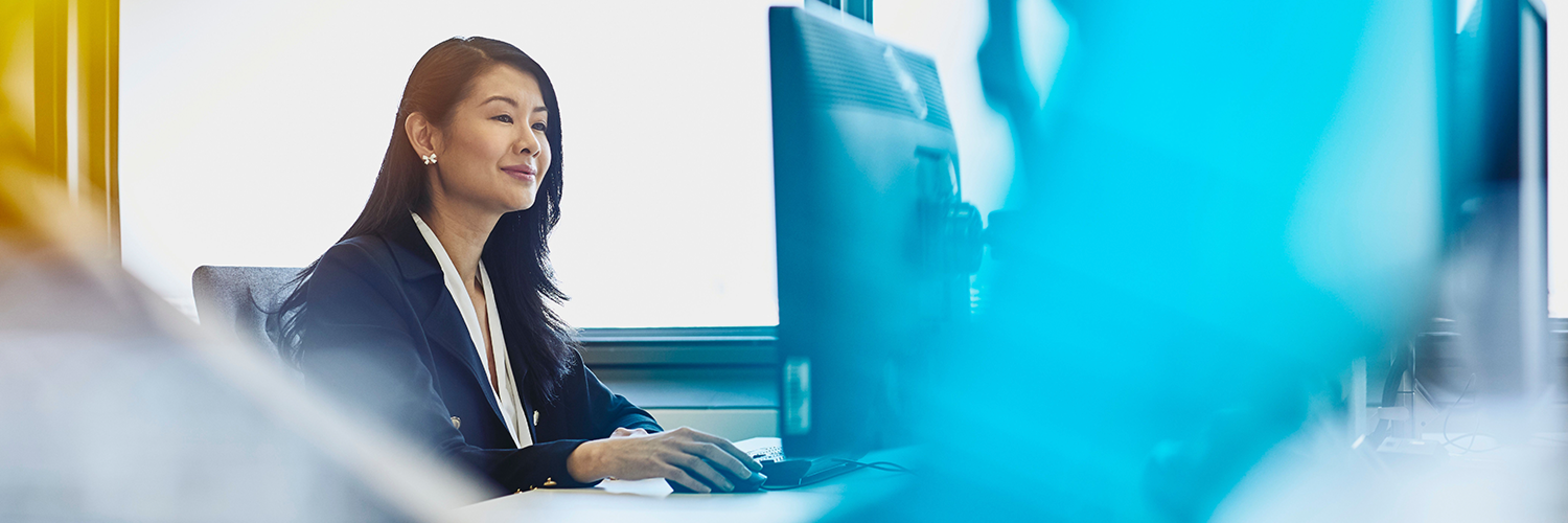 woman in suit seated at desk