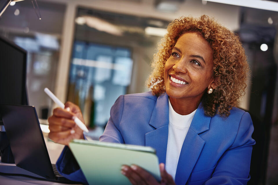 A woman holding a pen and a notepad